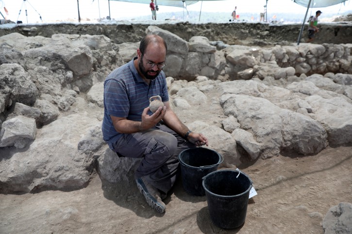  An archaeologist works at the archeological site near the city of Kiryat Gat, southern Israel, 08 July 2019. 